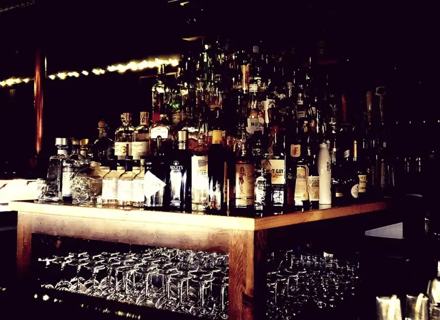 The back bar lit up with rows of whiskey bottles