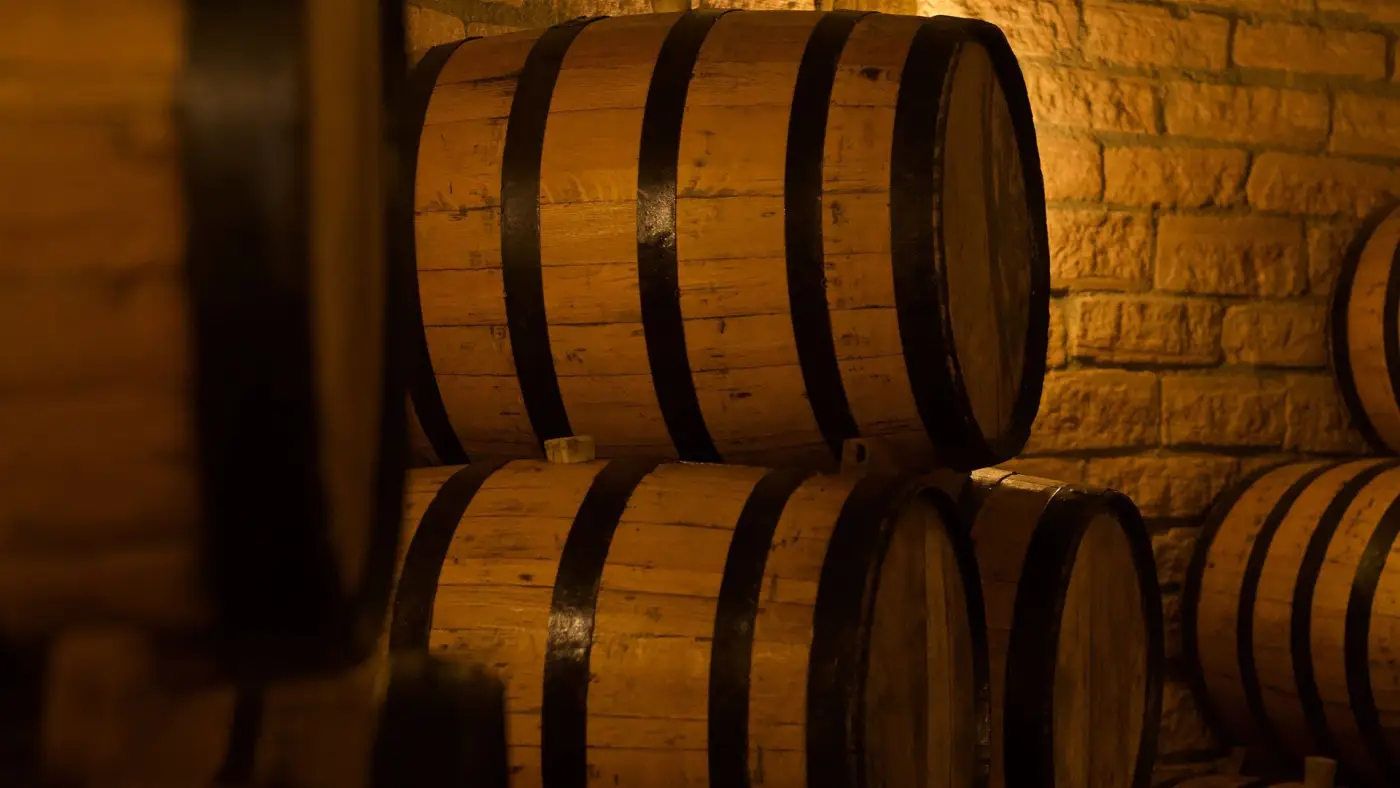 Stacked whiskey barrels against a brick wall