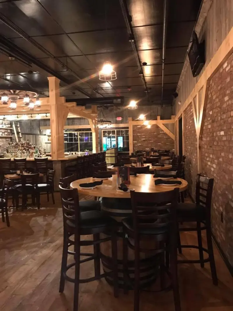 Dining room with round wood tables under warm pendant lights